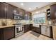 Eat-in kitchen featuring dark cabinetry, granite countertops, and stainless steel appliances at 9882 S Hoyt Ct, Littleton, CO 80127