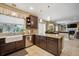 Well-lit kitchen features a farmhouse sink, granite countertops, dark cabinets, and modern stainless steel appliances at 9882 S Hoyt Ct, Littleton, CO 80127