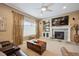 Cozy living room with a fireplace, large windows, and comfortable leather seating at 9882 S Hoyt Ct, Littleton, CO 80127