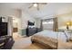 A primary bedroom with a ceiling fan, television, attached bathroom, and calming neutral color scheme at 9882 S Hoyt Ct, Littleton, CO 80127