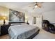 A primary bedroom with a ceiling fan, comfortable decor, picture window, and an adjacent hallway and sitting room at 9882 S Hoyt Ct, Littleton, CO 80127