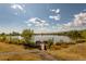 Relaxing view of a tranquil pond featuring a wooden deck and serene natural surroundings at 9882 S Hoyt Ct, Littleton, CO 80127