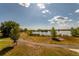 Scenic pond with a walking trail, green grass, trees, and a beautiful sky at 9882 S Hoyt Ct, Littleton, CO 80127