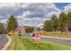 Community entrance adorned with American flags and professional real estate signage at 9882 S Hoyt Ct, Littleton, CO 80127