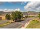 Roadside view featuring 'TrailMark' community sign, American flags, landscaping and mountain views at 9882 S Hoyt Ct, Littleton, CO 80127