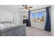 Bright bedroom features a gray bed, ceiling fan, dark dresser, and window with a view at 10053 Granite Hill Dr, Parker, CO 80134