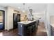 Spacious kitchen with dark wood floors, quartz counters, and a black refrigerator at 10053 Granite Hill Dr, Parker, CO 80134