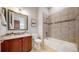 Full bathroom with tiled shower-tub, toilet, and vanity with cherry wood cabinets at 3565 New Haven Cir, Castle Rock, CO 80109