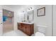 Bathroom features a wood vanity with double sinks, modern fixtures and white tile flooring at 3565 New Haven Cir, Castle Rock, CO 80109