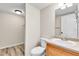 Bathroom with a toilet, sink, mirror, light fixture, and wood-look flooring at 22974 E Dorado Dr, Aurora, CO 80015