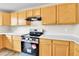 Updated kitchen boasts stainless steel appliances, wood cabinets, stylish lighting, and modern countertops at 22974 E Dorado Dr, Aurora, CO 80015