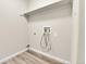 A simple laundry room with a shelf, hookups, and light wood flooring at 22974 E Dorado Dr, Aurora, CO 80015