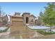 Charming home featuring a stone archway, two-car garage, and well-maintained landscaping at 15855 Wild Horse Dr, Broomfield, CO 80023