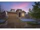 Charming home featuring a stone archway, two-car garage, and well-maintained landscaping at 15855 Wild Horse Dr, Broomfield, CO 80023