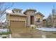 Attractive home with a stone entryway, large windows, and a spacious two-car garage at 15855 Wild Horse Dr, Broomfield, CO 80023