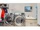 Laundry room featuring front-load washer, dryer, utility sink, and upper cabinets at 15855 Wild Horse Dr, Broomfield, CO 80023