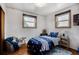 Bedroom with hardwood floors, two windows, and a cozy beanbag chair at 7839 Florado St, Denver, CO 80221