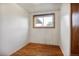 Bedroom with hardwood floors, one window, and minimalist decor at 7839 Florado St, Denver, CO 80221