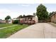 A well-maintained home with a large driveway, lawn, and covered porch at 7839 Florado St, Denver, CO 80221