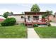 Charming home with covered porch, well-kept lawn, and walkway leading to the front door at 7839 Florado St, Denver, CO 80221