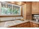 Bright kitchen with wood cabinets, modern sink, large window with natural light at 7839 Florado St, Denver, CO 80221
