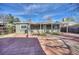 A view of the backyard, featuring a covered patio with a stone paver deck, lawn, and a well-maintained house at 1629 Valentia St, Denver, CO 80220