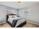 Bedroom featuring a upholstered bed, neutral tones, and natural light from two windows at 1629 Valentia St, Denver, CO 80220