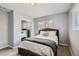 Bedroom featuring a upholstered bed, neutral tones, mirrored closet and natural light from a window at 1629 Valentia St, Denver, CO 80220