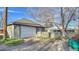 Spacious detached garage with a white door, set in a backyard with mature trees at 1629 Valentia St, Denver, CO 80220