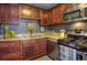 Kitchen features stainless appliances, granite countertops, dark wood cabinets and gray walls at 1629 Valentia St, Denver, CO 80220