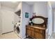 Bright laundry room with modern appliances, a door to the outside, and a decorative cabinet with a mirror at 1629 Valentia St, Denver, CO 80220