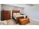 Comfortable bedroom features neutral tones, a wooden bed set, and soft carpet at 1629 Valentia St, Denver, CO 80220