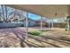 Covered outdoor patio area with a red brick paver deck and view of detached garage and fenced backyard at 1629 Valentia St, Denver, CO 80220