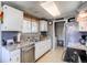 Functional kitchen with white cabinets, stainless steel appliances, and an adjacent laundry area at 9310 Pierce St, Broomfield, CO 80021