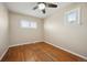 Well-lit bedroom featuring hardwood floors, a ceiling fan, and multiple windows at 2345 S Williams St, Denver, CO 80210