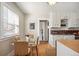 Bright eat-in kitchen with wood floors, white cabinets, and a stylish glass dining table set at 2345 S Williams St, Denver, CO 80210