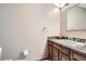Powder room with a single sink vanity, dark countertop, mirror, and neutral walls at 1376 S Laredo Ct, Aurora, CO 80017