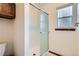 Shower room features clear glass sliding doors, white tile, and a window for natural light at 1376 S Laredo Ct, Aurora, CO 80017