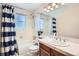 Bathroom featuring a blue striped shower curtain, white tile, and modern vanity at 1376 S Laredo Ct, Aurora, CO 80017