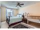 Bright bedroom featuring bed, crib, and bedside table with ample natural light from a large window at 1376 S Laredo Ct, Aurora, CO 80017