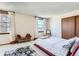 Sunny bedroom featuring white walls, neutral carpet, two windows, and a sliding closet at 1376 S Laredo Ct, Aurora, CO 80017