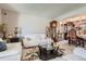 Spacious living room with white sofas, glass tables, grandfather clock and dining room view at 1376 S Laredo Ct, Aurora, CO 80017