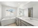 Bright bathroom featuring a double vanity, soaking tub and large window for ample natural light at 8816 Whiteclover St, Littleton, CO 80125