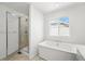 Stylish bathroom featuring a walk-in shower and separate soaking tub with abundant natural light at 8816 Whiteclover St, Littleton, CO 80125