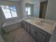 Relaxing bathroom showcasing a soaking tub and dual sink vanity with gray cabinets at 8816 Whiteclover St, Littleton, CO 80125