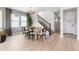 Bright dining room featuring wood floors, large windows, decorative lighting, and staircase access at 8816 Whiteclover St, Littleton, CO 80125