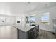 Kitchen island features a stainless sink, breakfast bar, modern faucet, and is open to the living area at 8816 Whiteclover St, Littleton, CO 80125