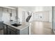 Kitchen island sink with barstool seating overlooks the staircase and light-filled open living space at 8816 Whiteclover St, Littleton, CO 80125