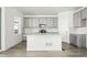 Bright kitchen features grey cabinetry, stainless appliances, white subway tile backsplash and large center island at 8816 Whiteclover St, Littleton, CO 80125