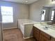 Bathroom showcasing a large window, soaking tub, single sink, and wooden cabinets at 21580 Longs Peak Ln, Parker, CO 80138